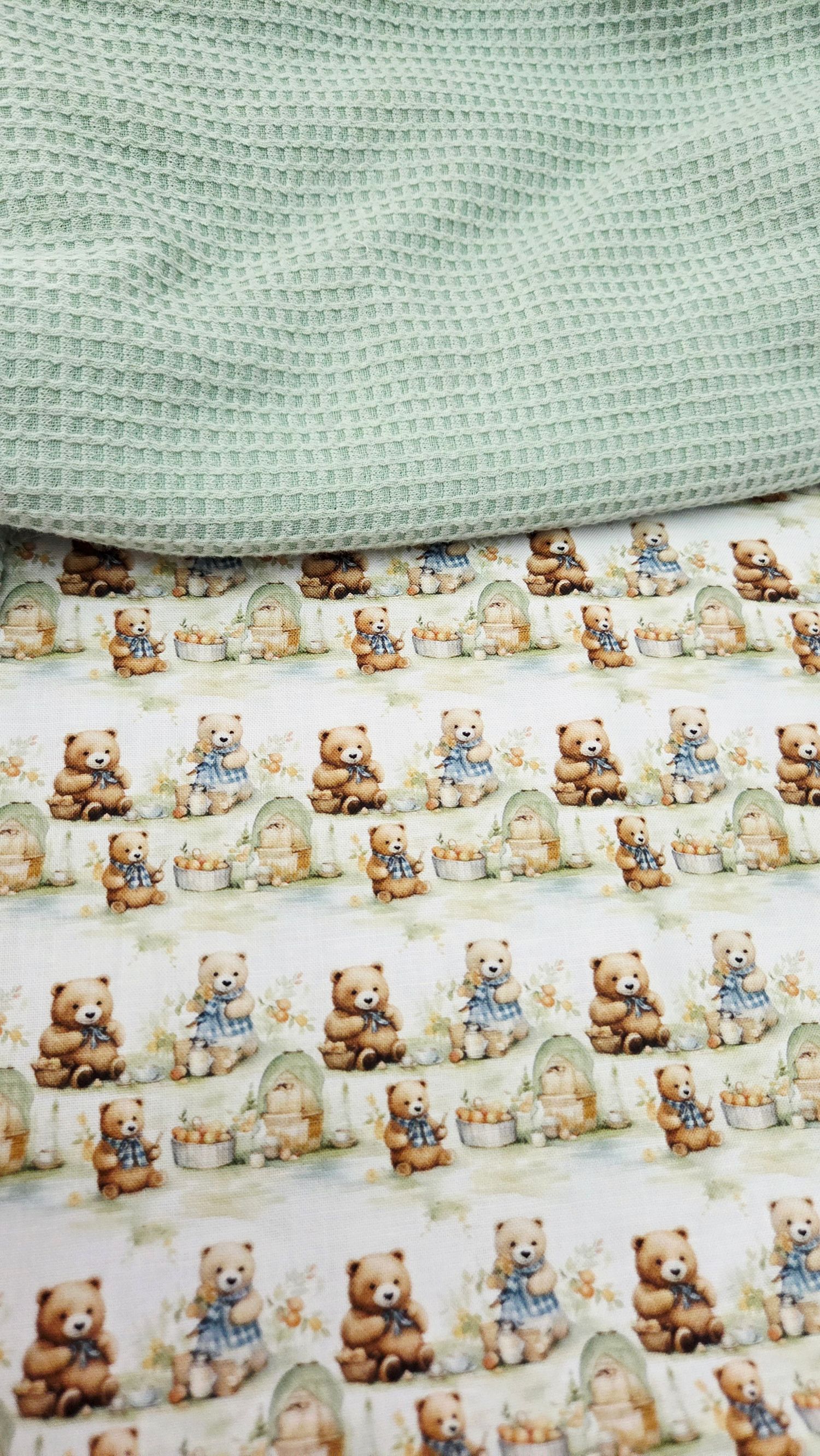 Mint green waffle knit fabric layered over white cotton fabric printed with cute teddy bears and beehives pattern.
