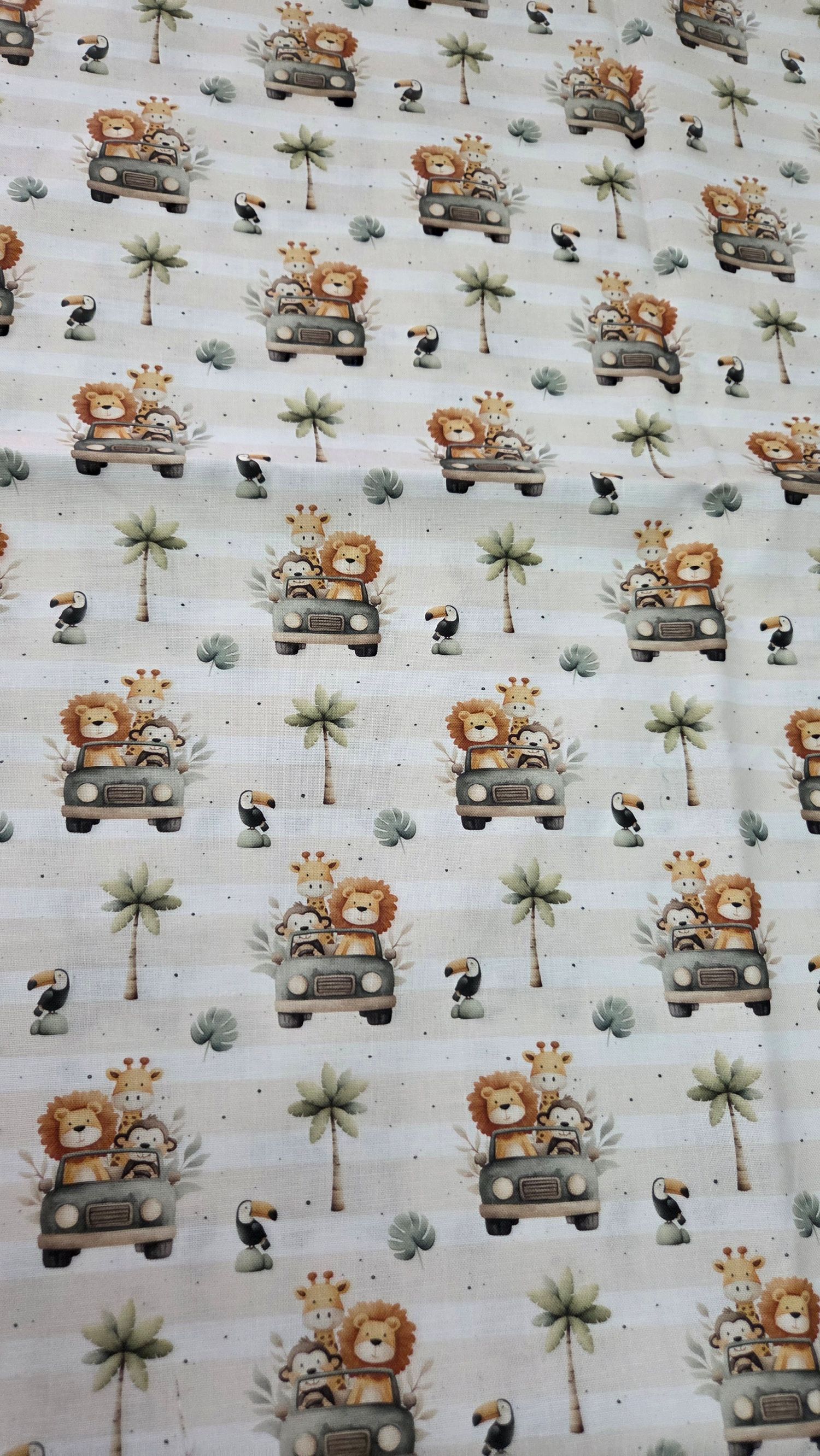 Safari animal fabric featuring lions, giraffes, toucans, and palm trees on a cream background.