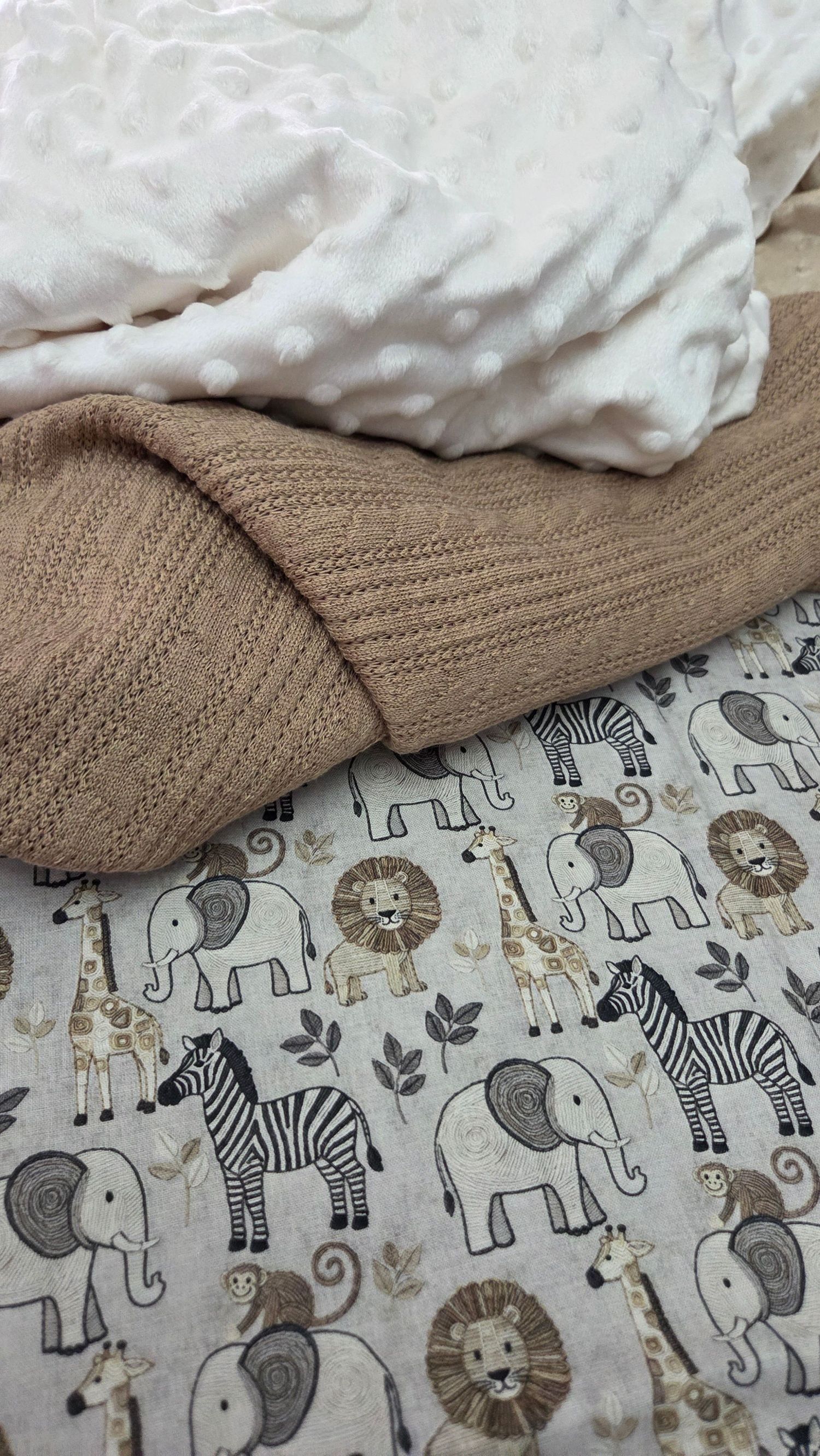 Cozy baby blankets featuring safari animals including elephants, zebras, lions, and giraffes alongside soft knit and minky dot fabrics.