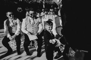 Vintage black and white photo of people sitting in a row at what appears to be a sporting event or gathering.