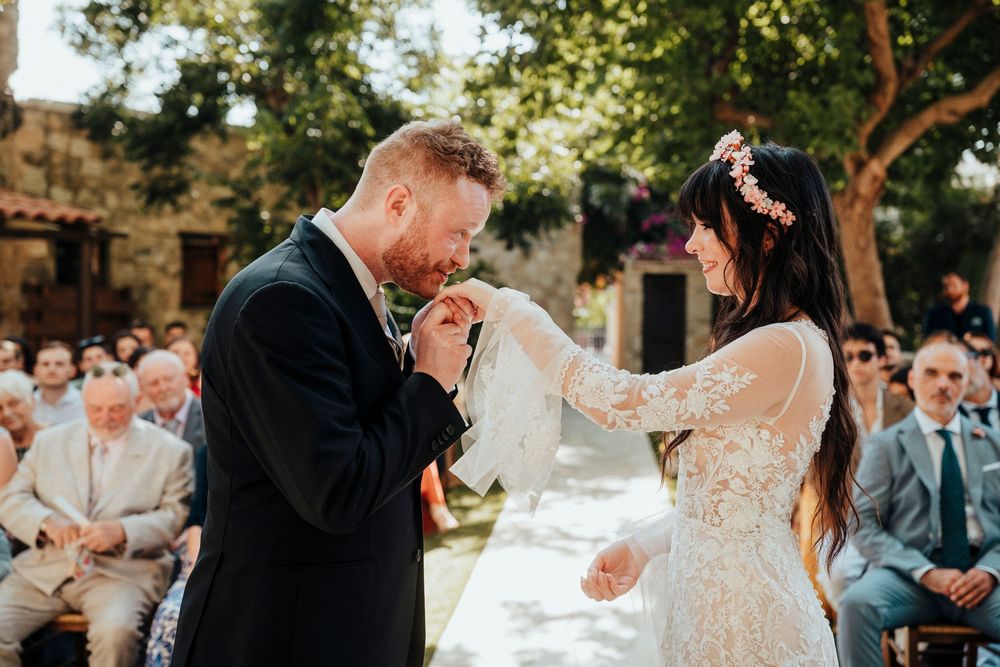 A couple shares their first dance at an outdoor wedding celebration surrounded by guests and natural scenery.