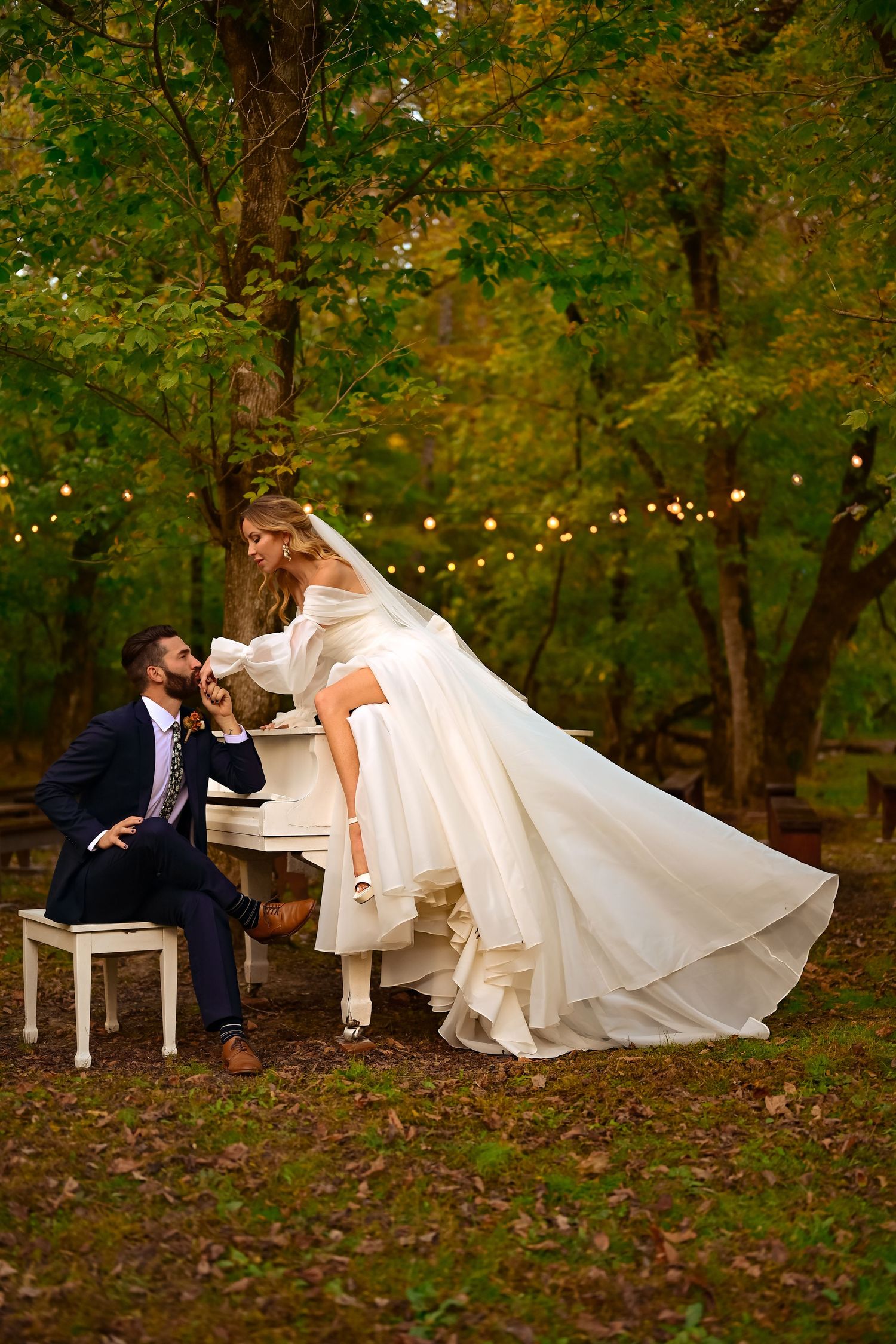 Romantic wedding portrait with flowing white dress in golden sunset light.