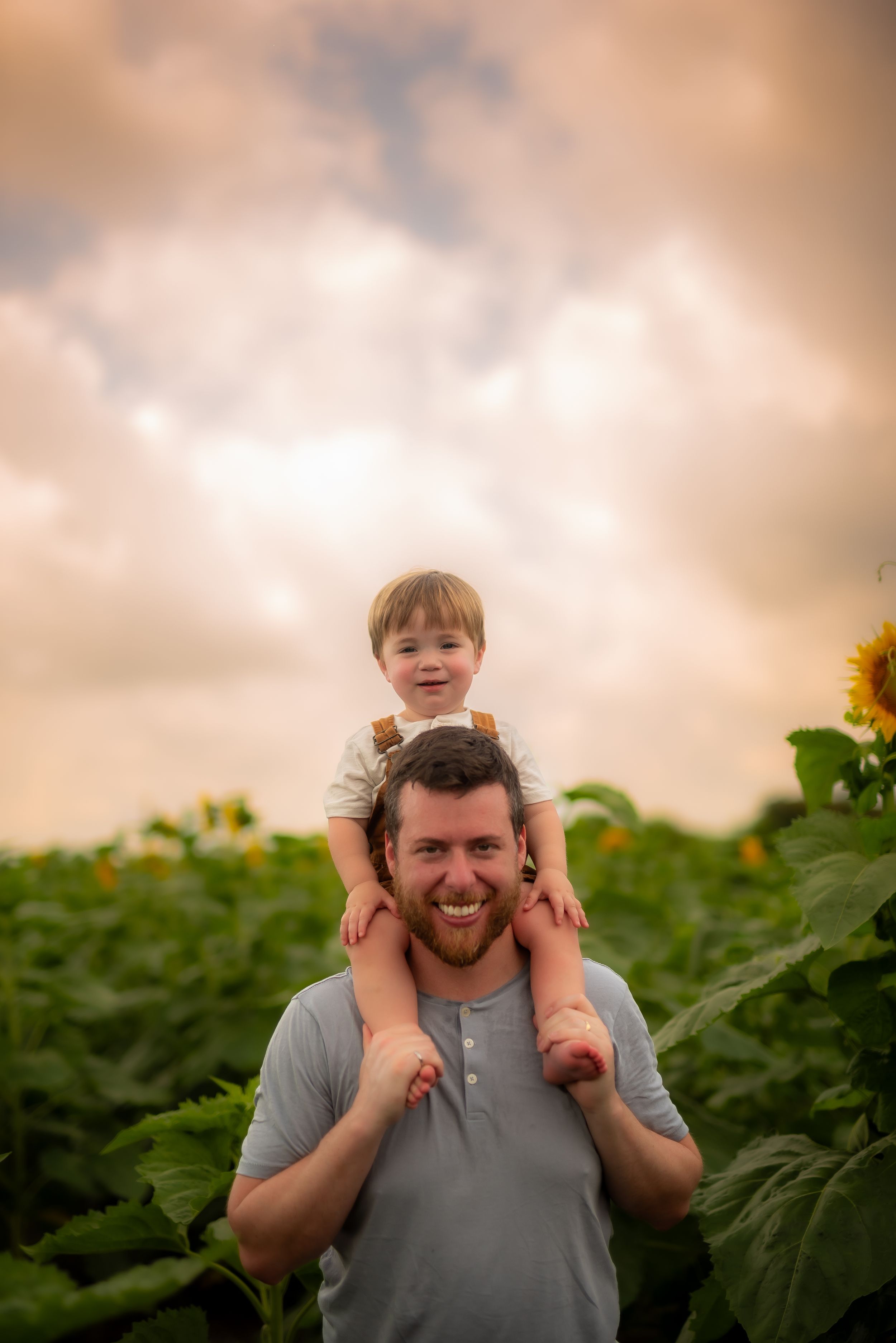 Joyful moment captured in sunflower field during golden hour.