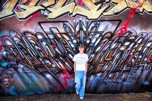 Colorful graffiti art spans across a long concrete wall with vibrant designs and patterns in blue and red tones.