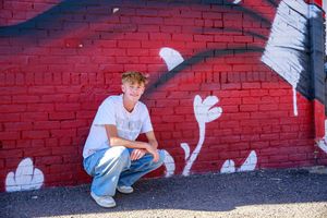 Red brick wall with white graffiti art creates urban photography setting.