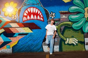 Colorful street art mural featuring a shark mouth, geometric shapes, and tropical elements painted on an urban wall.