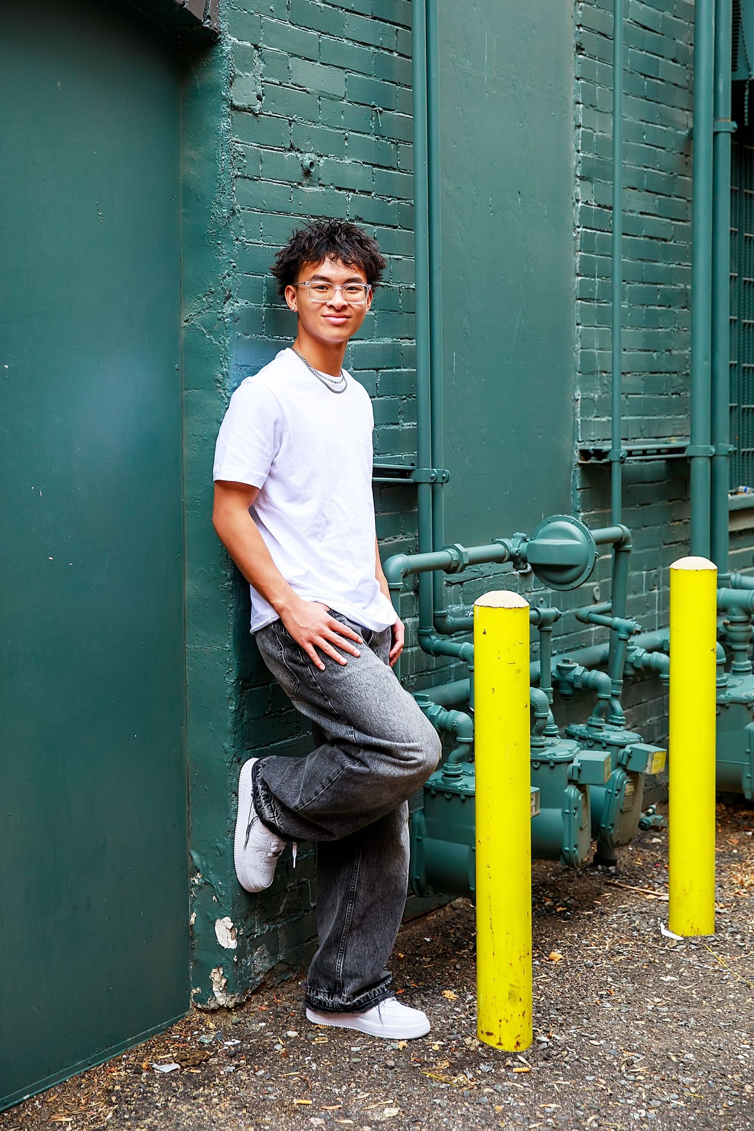 A sequence of three photos showing someone in white shirt and grey pants jumping over yellow parking bollards.