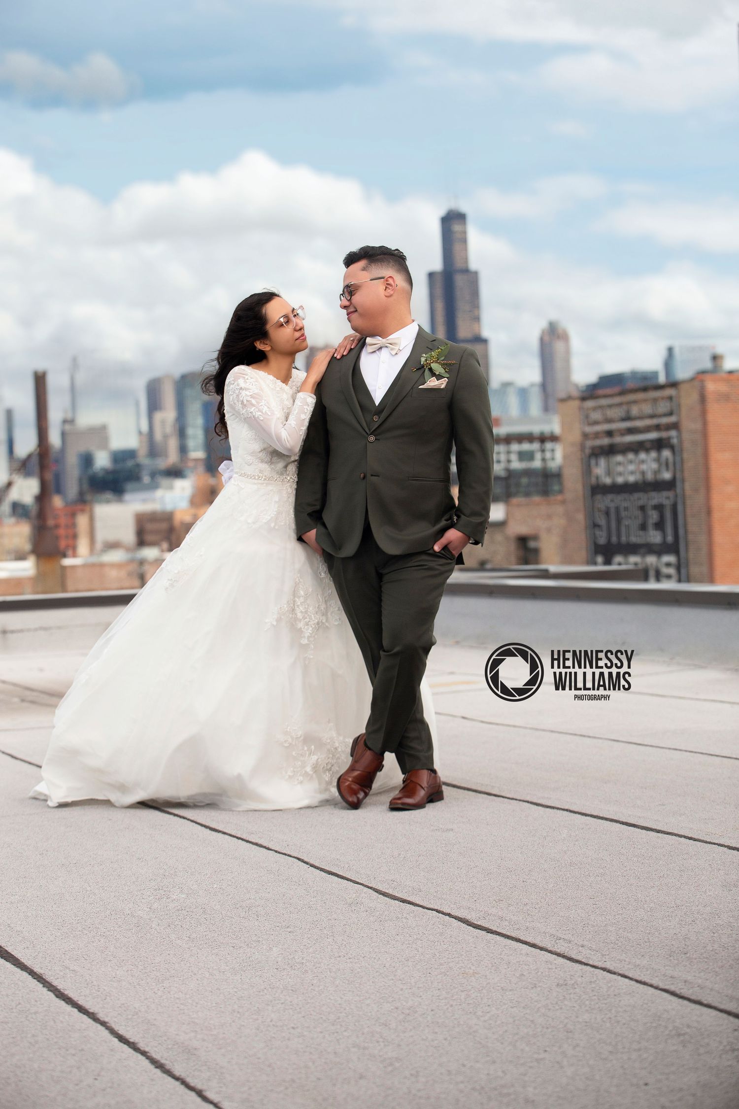 A romantic marriage proposal scene in front of large letters spelling MARRY ME with string lights in a rustic setting.