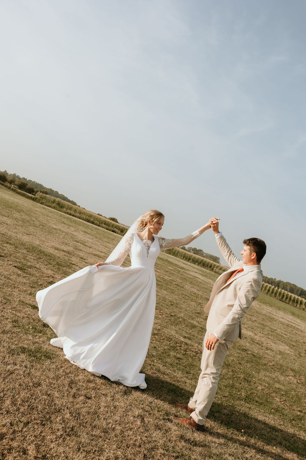 A couple dances together in an open field, with the person in white spinning dramatically across the frame.