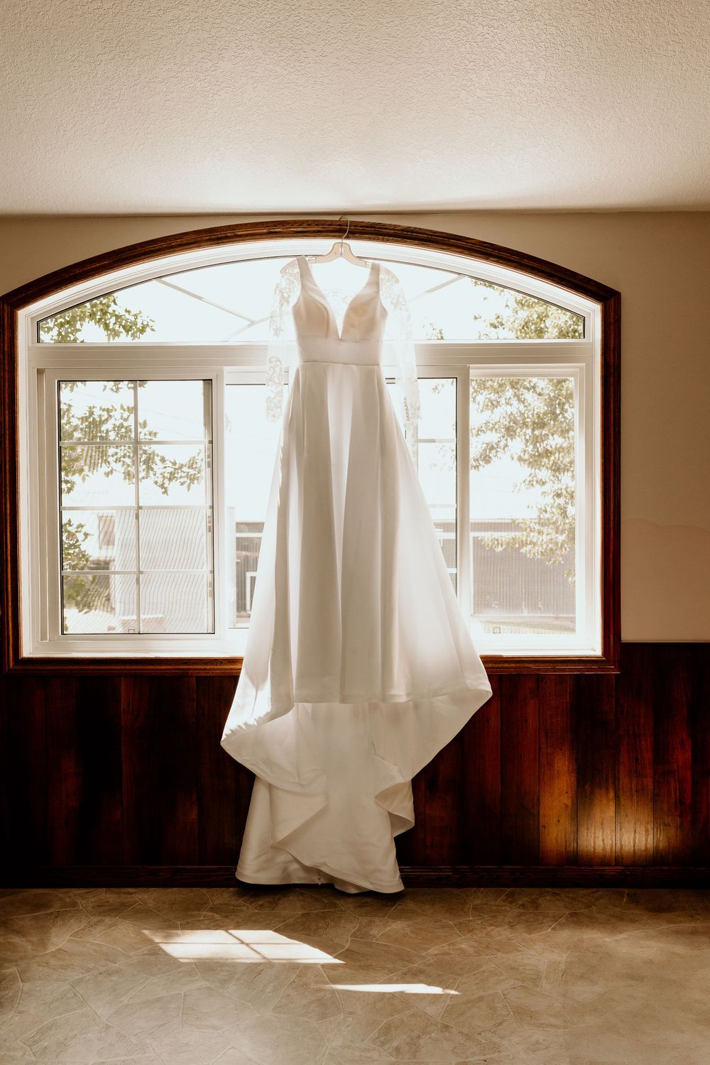 A sequence of sepia-toned photos showing a wedding dress hanging in front of arched windows with dark wood paneling.
