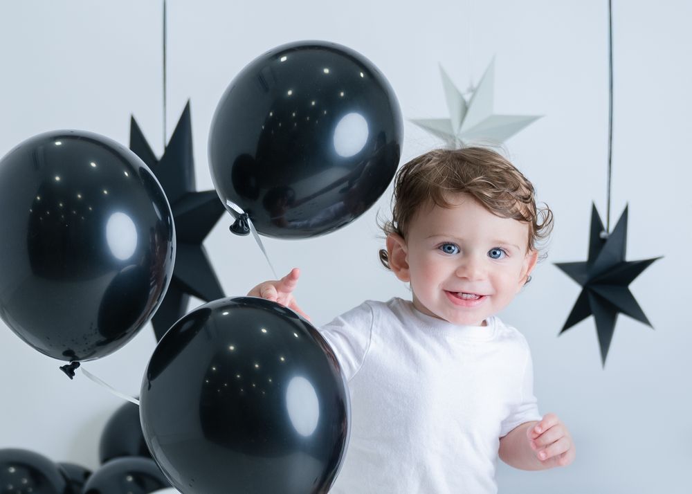 Black and white party scene with balloons, stars and decorative elements for a celebration.