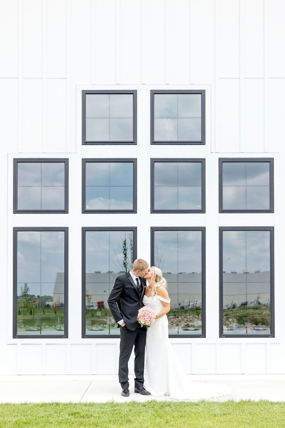 Elegant white building exterior with modern windows creating a symmetrical architectural pattern.