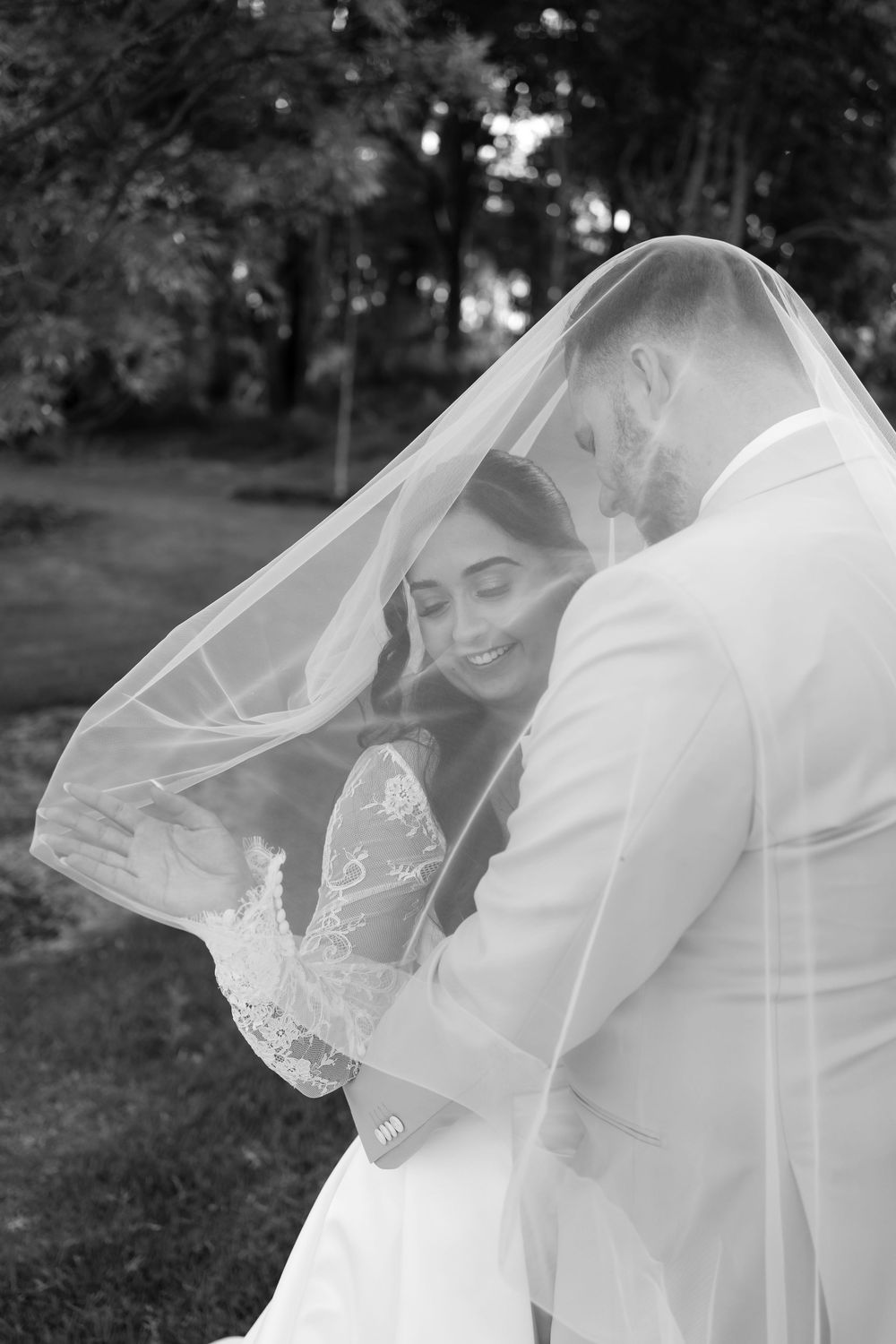A romantic black and white wedding photo series showing a bride's veil flowing dramatically in the wind.