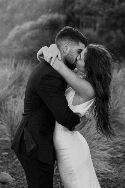 Intimate black and white portrait of couple embracing during outdoor wedding photoshoot.