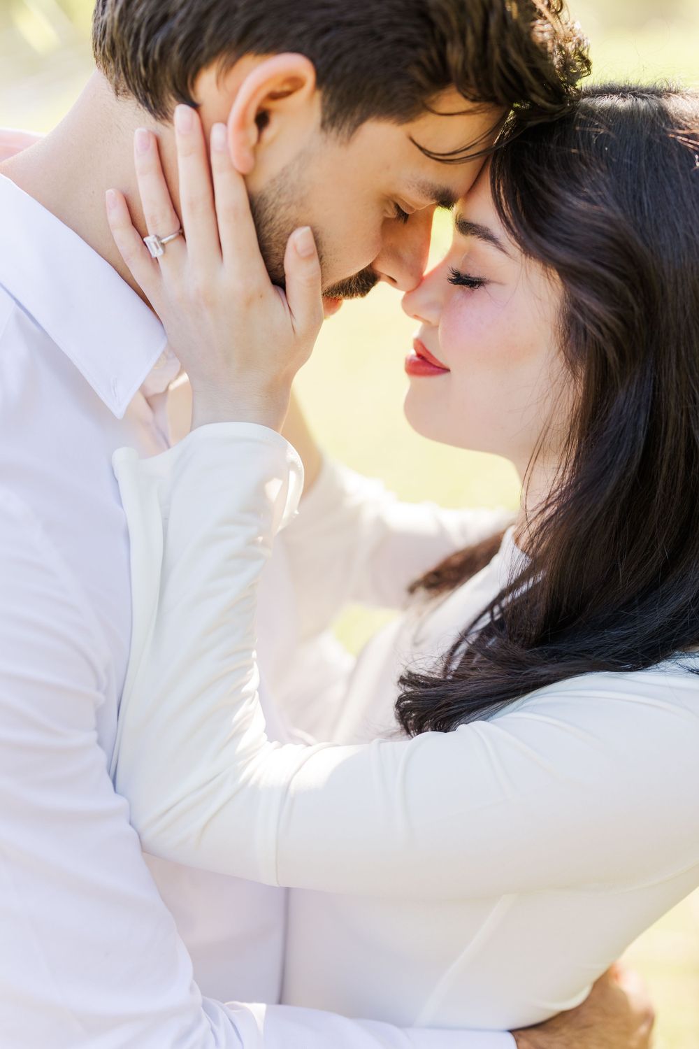 A romantic close-up moment between a couple dressed in white.