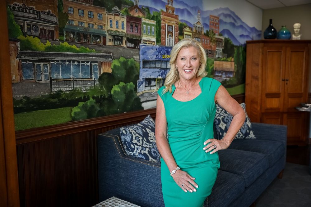 Interior scene with green shirt against backdrop of landscape artwork and wooden decor.