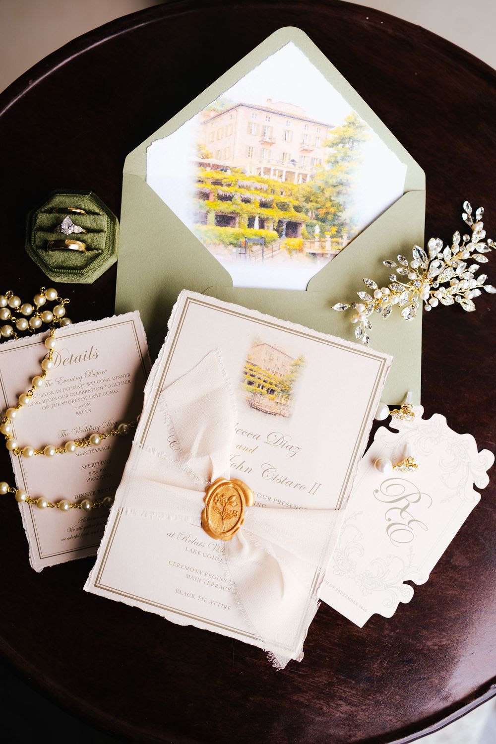 Elegant wedding invitation suite with gold wax seal, sage green envelope, watercolor venue illustration, and crystal hair accessories on dar