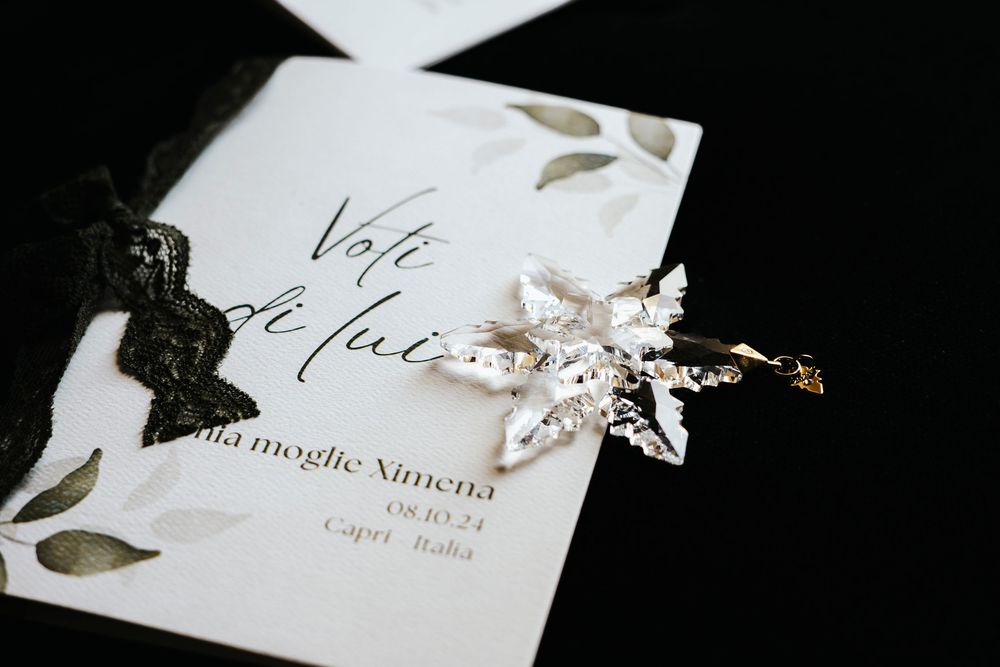 Elegant wedding invitation and details displayed with soft white ribbons and floral accents.