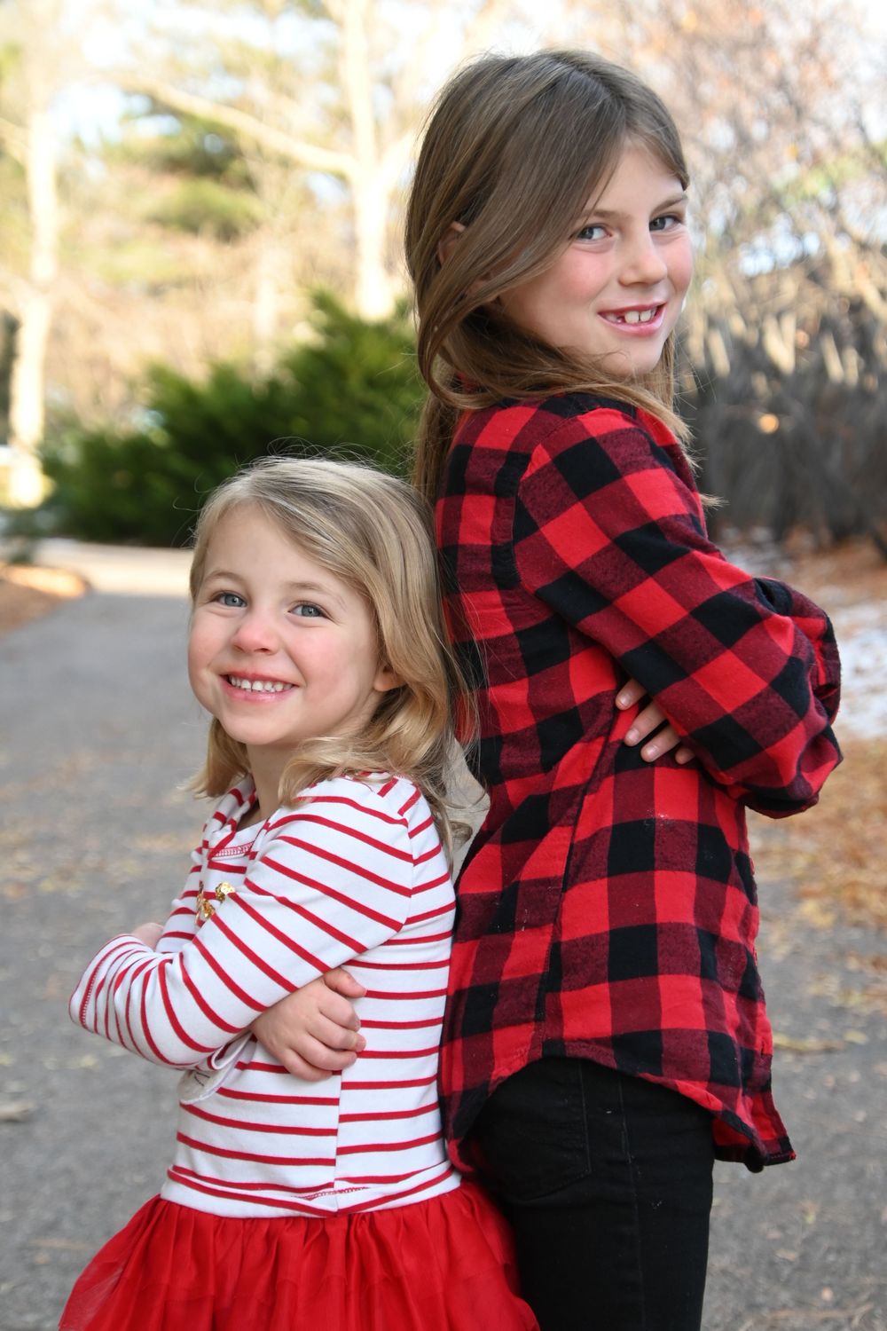 A tender moment captured in a series of photos showing a red buffalo plaid shirt and striped top embracing outdoors.
