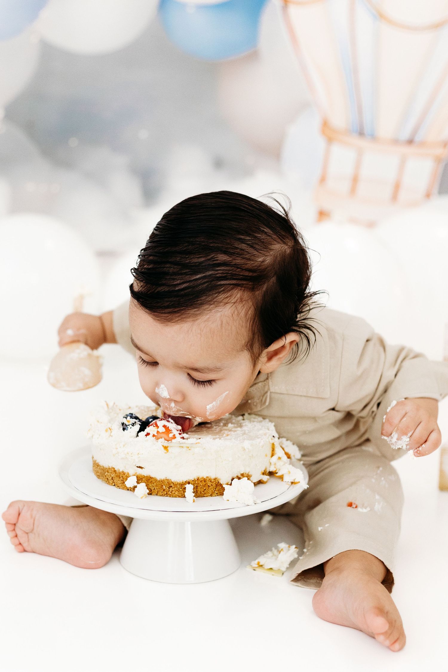 Happy baby smashing birthday cake.