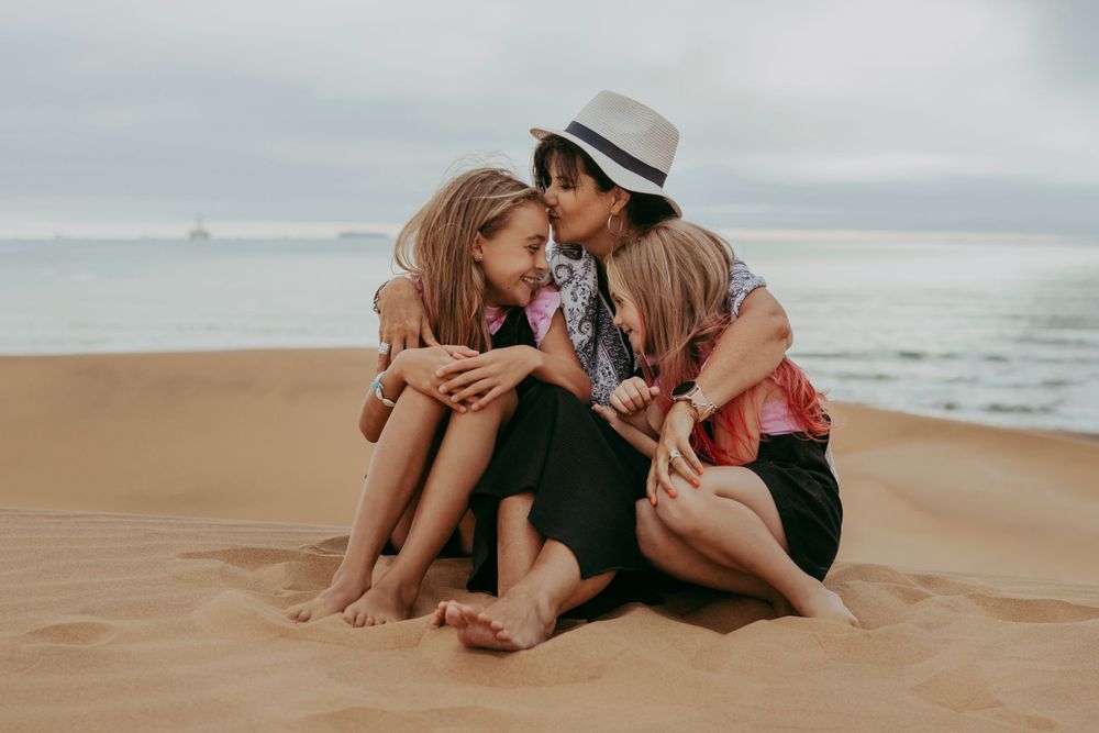 A family enjoying a photoshoot at the beach in Swakopmund, with the stunning backdrop of sand dunes and the ocean