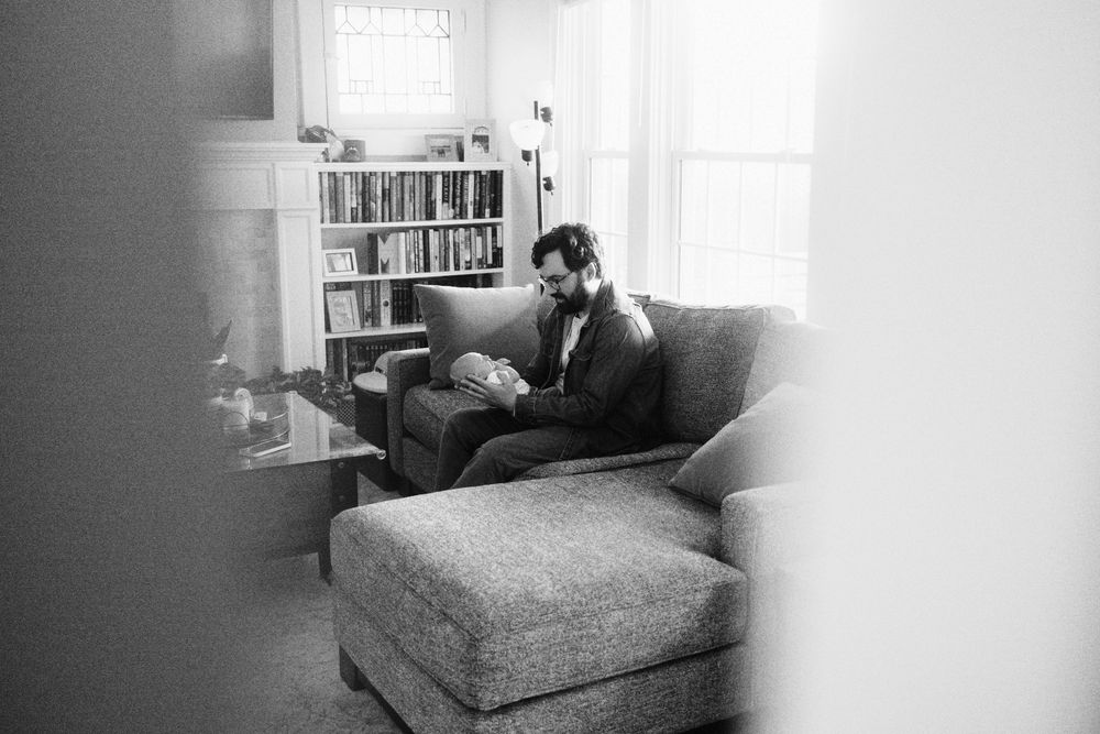 A black and white photograph shows seven sequential frames of someone resting on a couch or bed.