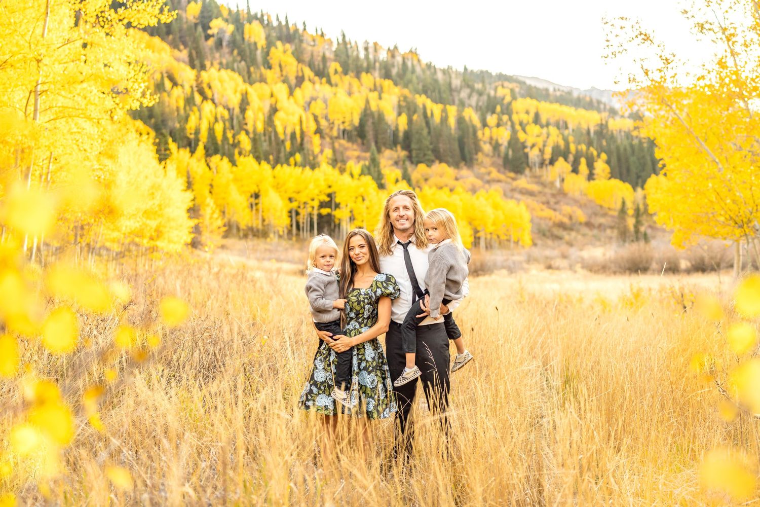 A group poses together in a golden autumn meadow with aspen trees in the background at White Pine Campground.