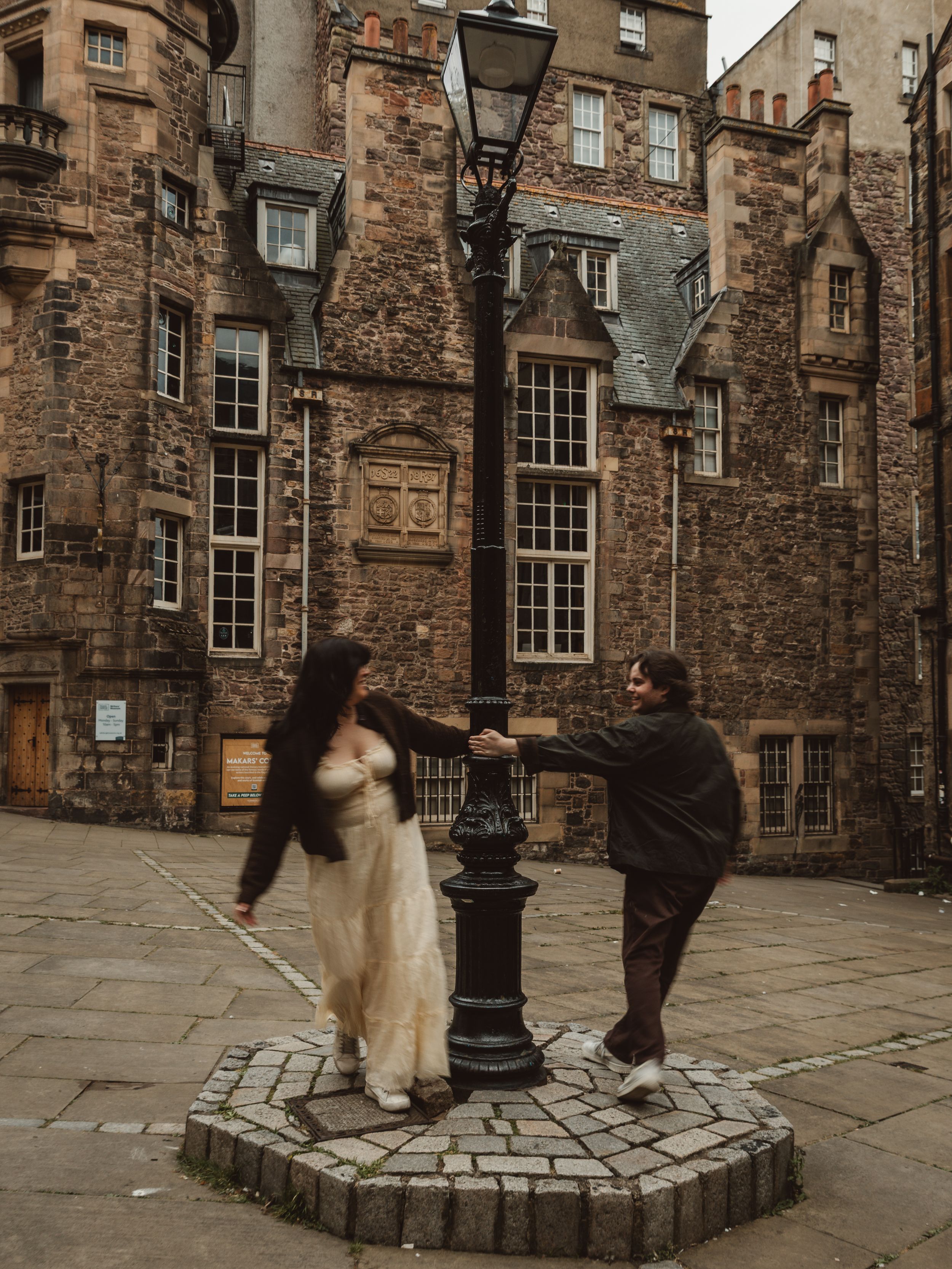 Cobblestone courtyard surrounded by historic stone buildings with traditional windows and architecture.