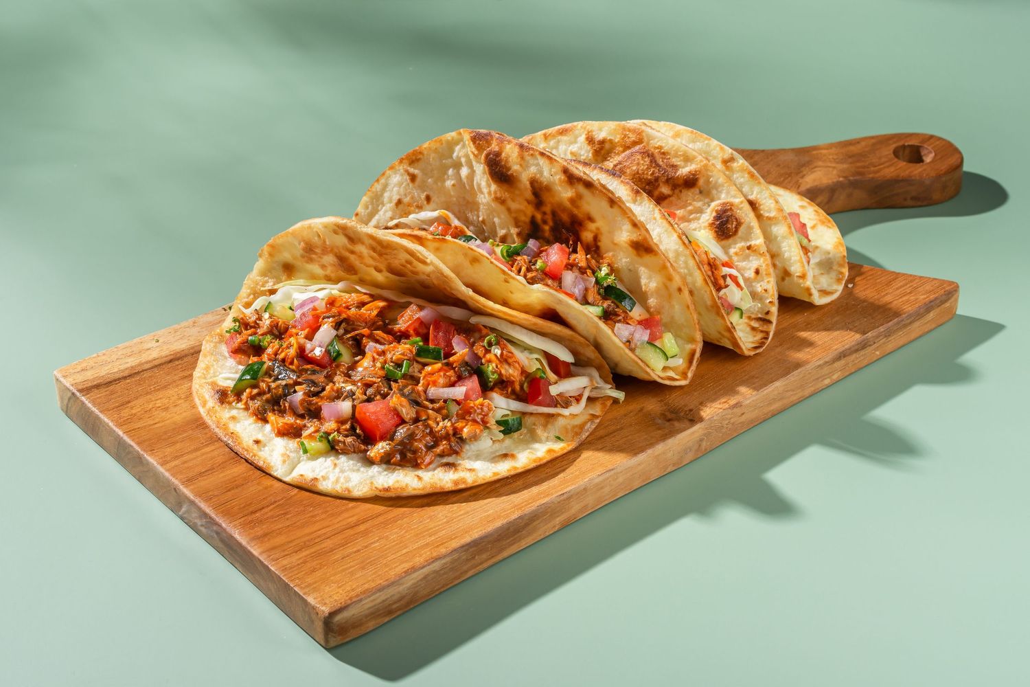 Homemade tacos served on wooden boards with fresh toppings and garnishes.
