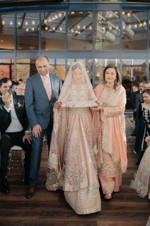 Traditional South Asian wedding ceremony in an elegant venue with string lights and glass windows.