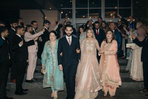 Wedding guests celebrate during an elegant indoor celebration with traditional Pakistani attire.