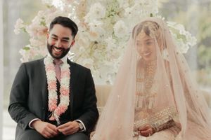 Traditional South Asian wedding ceremony with floral decor and couple in cultural attire.
