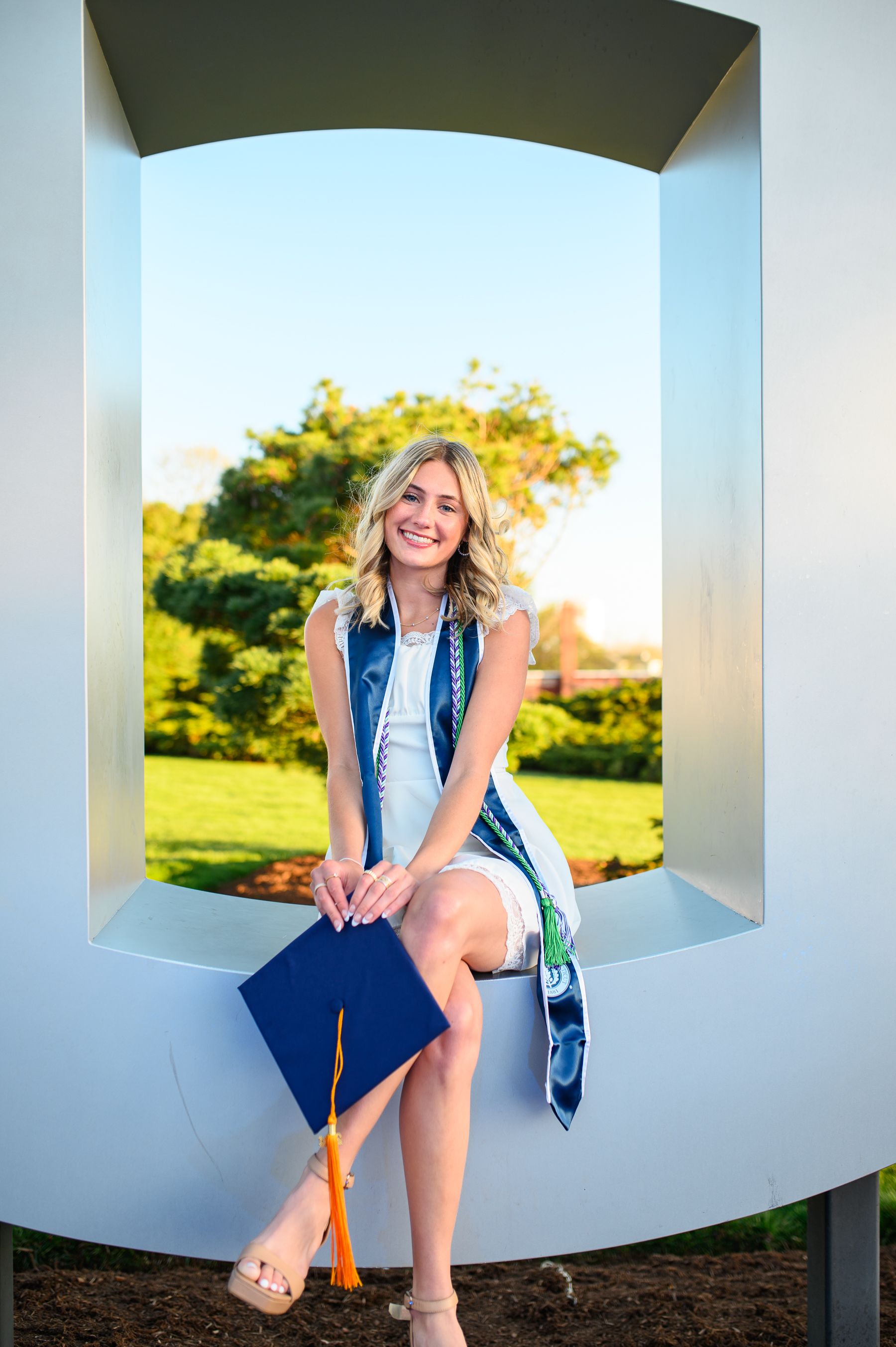 Graduation photo in architectural  frame with diploma and honors stole.