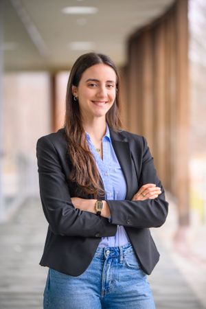 Professional business portrait in a modern office hallway showing corporate style.