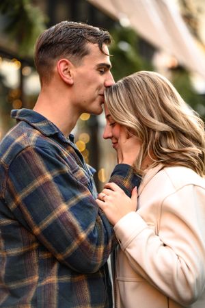 Intimate couple portrait with plaid shirt and cream sweater in warm evening light.