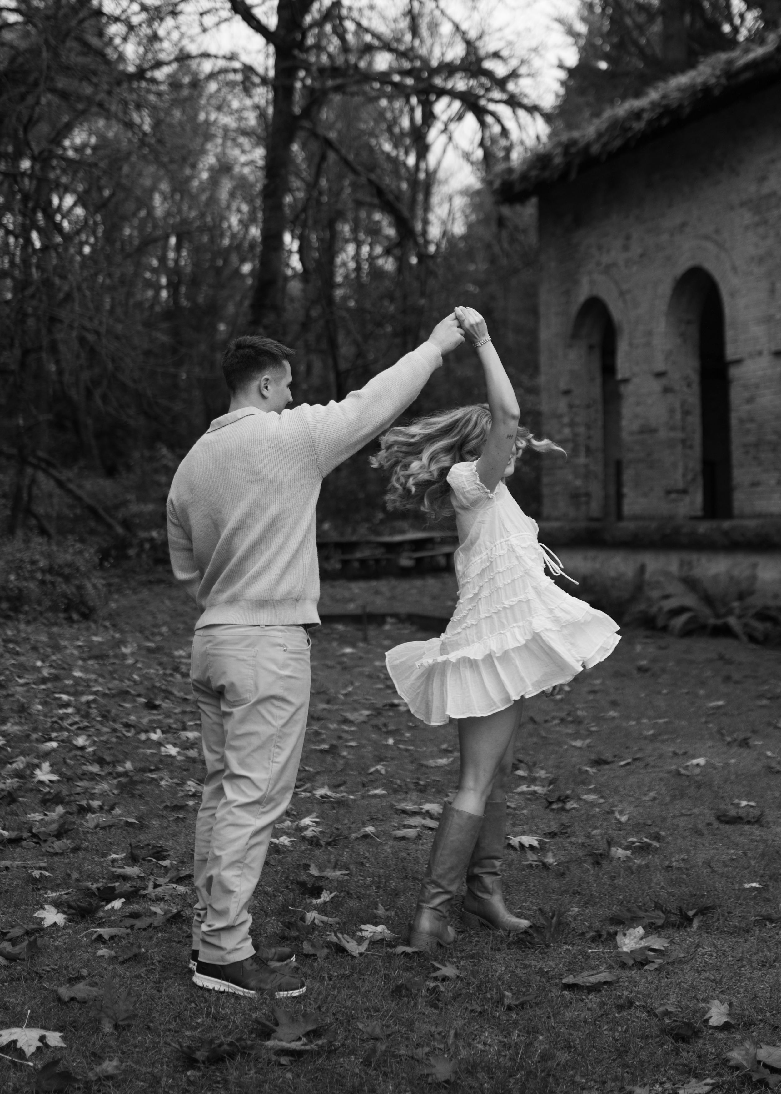 A series of black and white photos showing graceful dance movements on fallen leaves in a wooded outdoor setting.