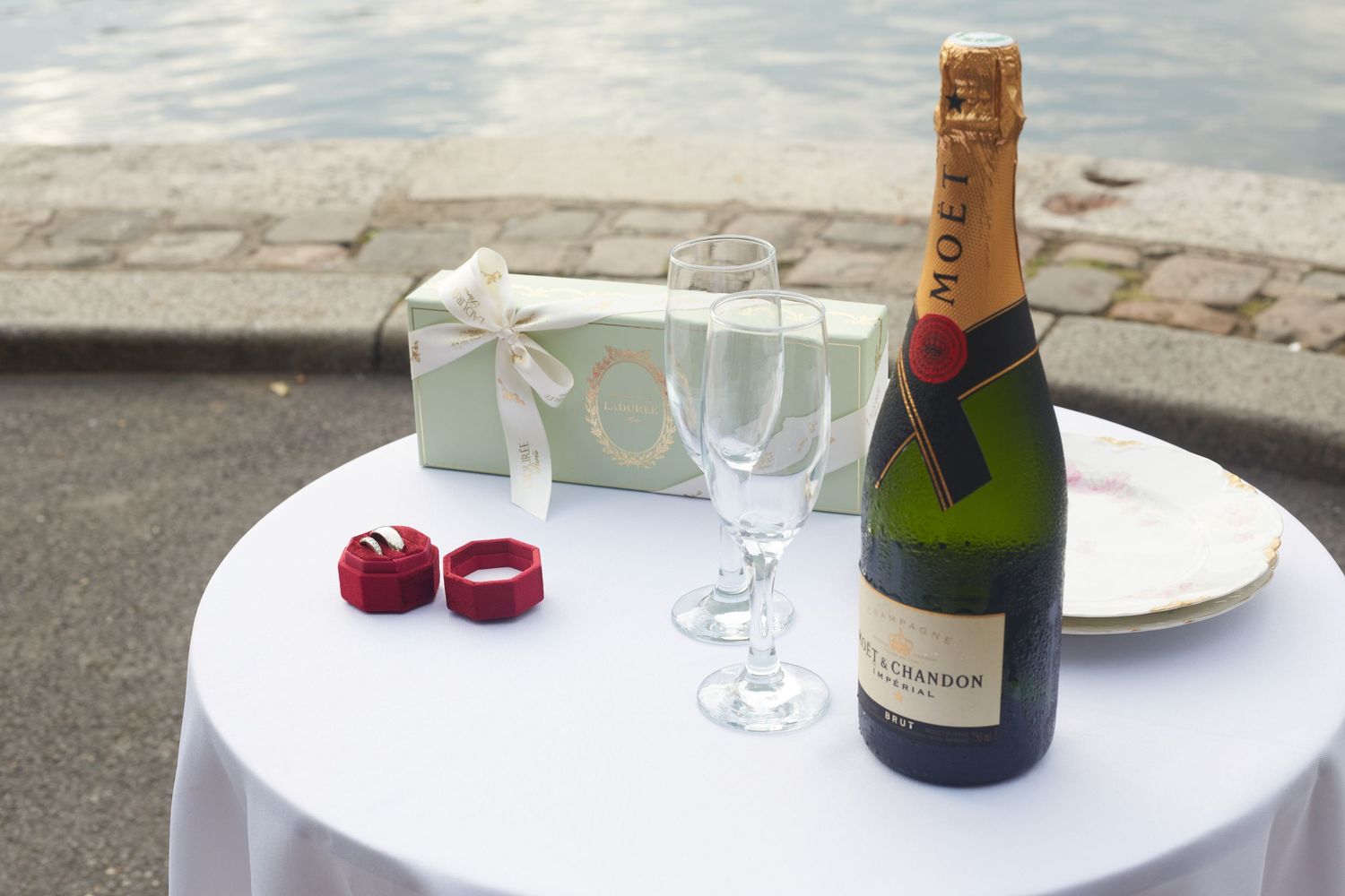 Wedding reception setup with champagne bottles and crystal glasses on elegant white tablecloths.