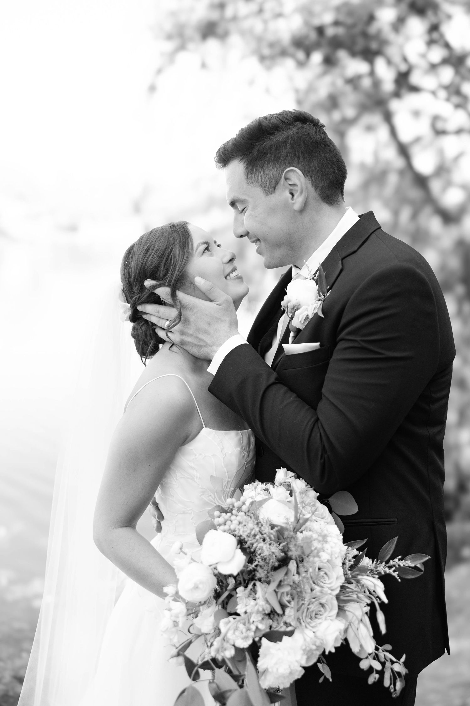 Intimate Black and White portrait of Bride and and groom smiling at each other at lakeside pavilion in Chico, California