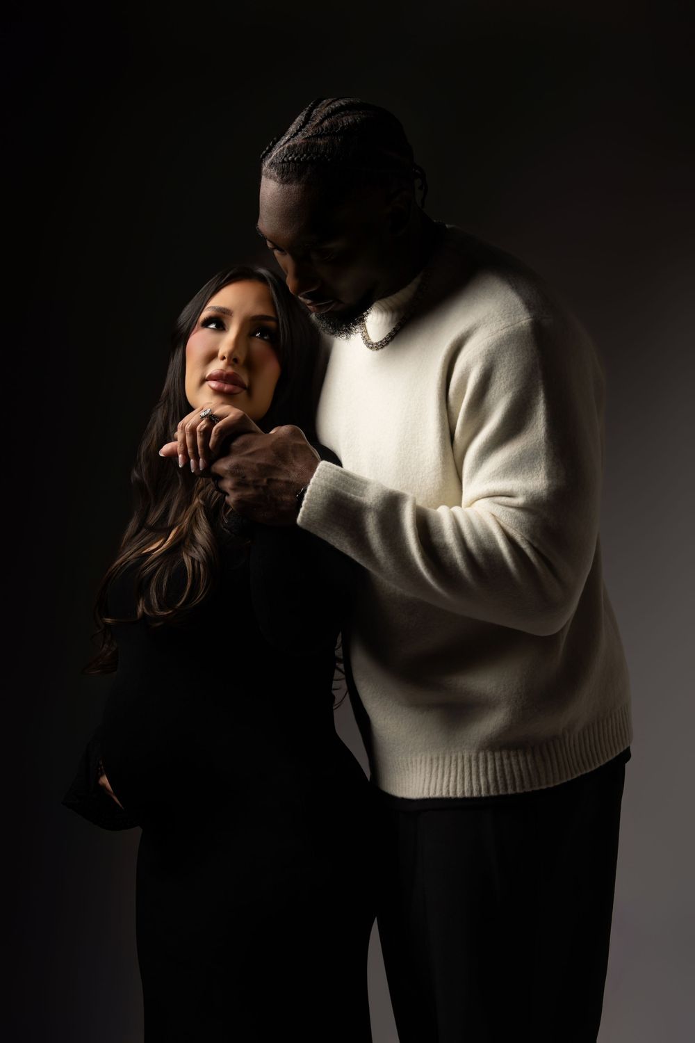 A series of dramatic black and white photos showing intimate poses between two figures in a dark studio setting.