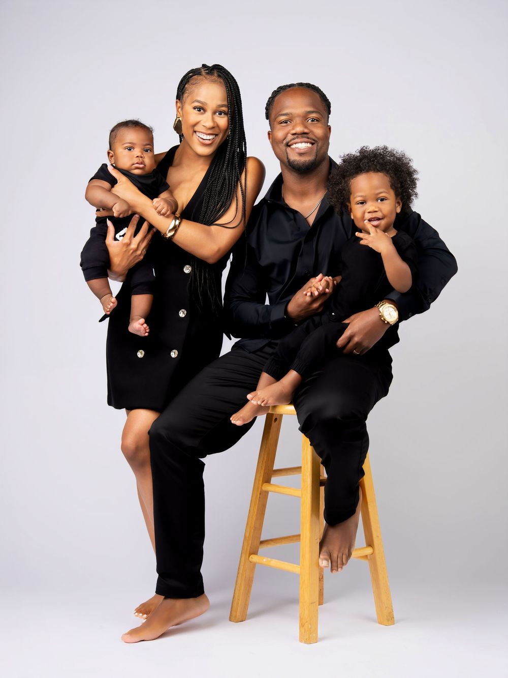 A family wearing matching black outfits poses playfully together in three different studio portraits against a white backdrop.