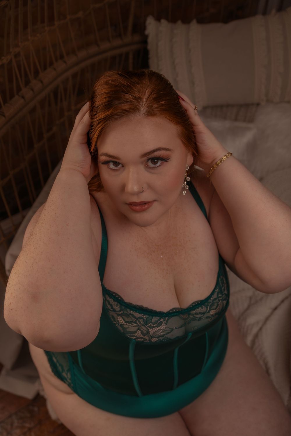 Portrait in emerald green lace lingerie with warm lighting and soft romantic aesthetic featuring a rustic backdrop.