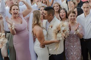 Couple kissing under floral arch in Cabo San Lucas