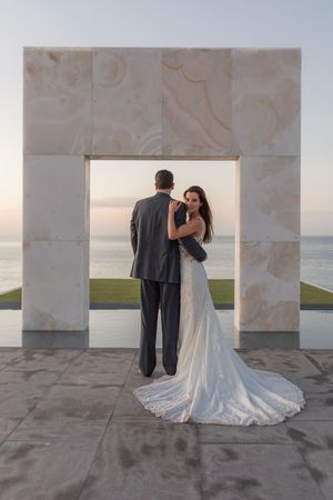 Newlyweds walking hand in hand on Cabo beach