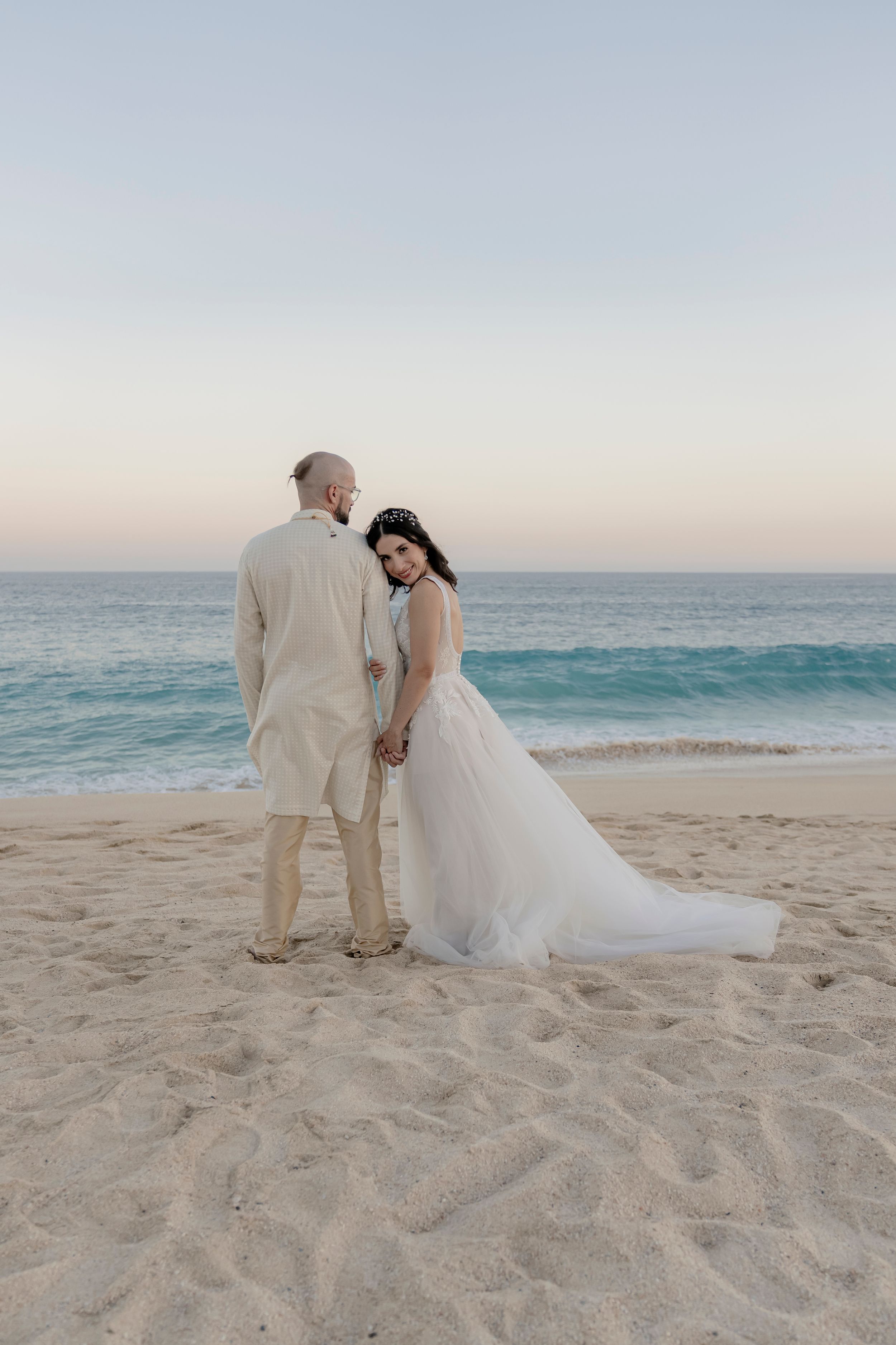 Couple walking along shoreline after ceremony