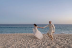 Bride portrait with veil flowing in ocean breeze