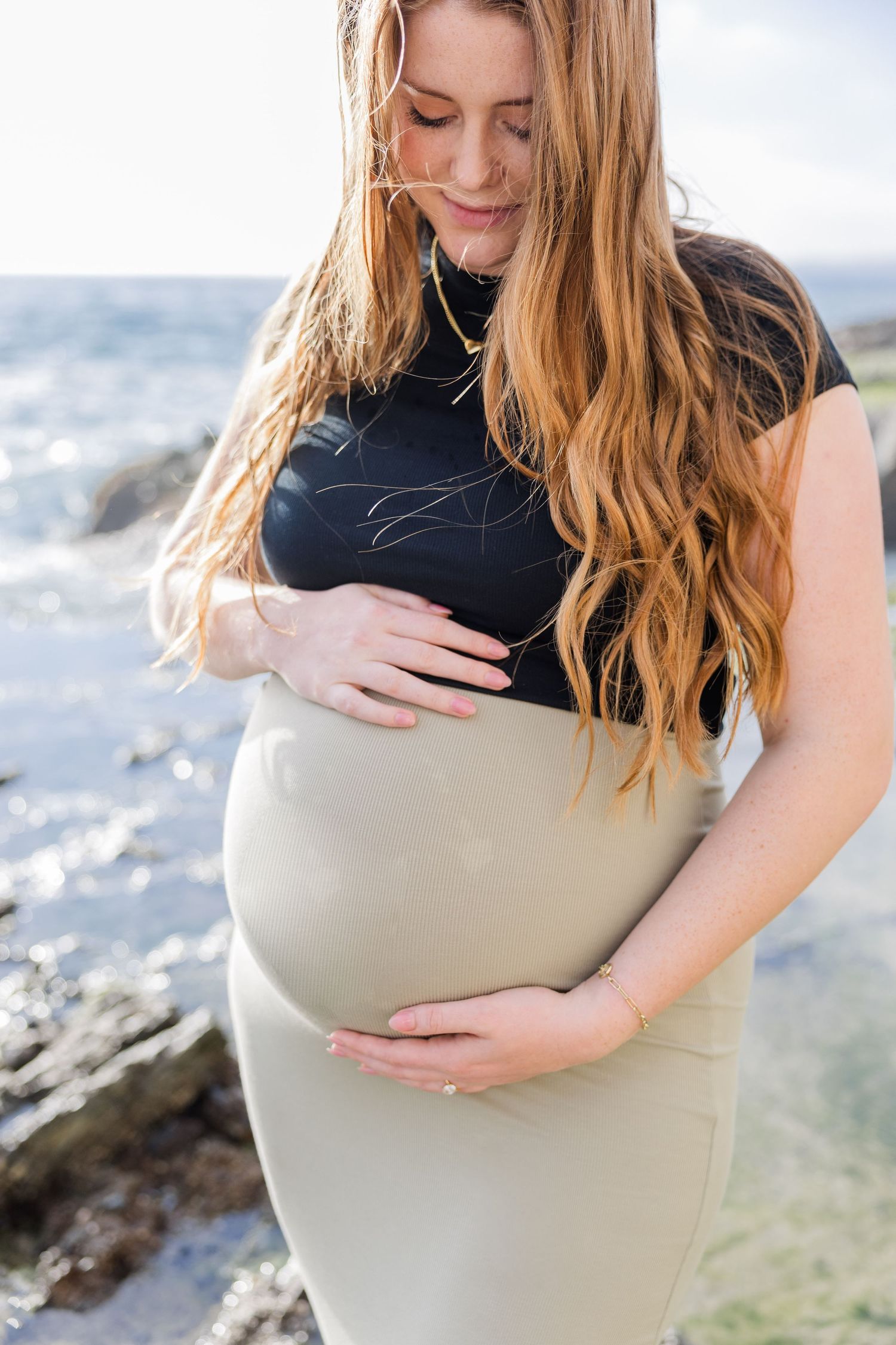Maternity session with mom looking down at belly in Laguna Beach