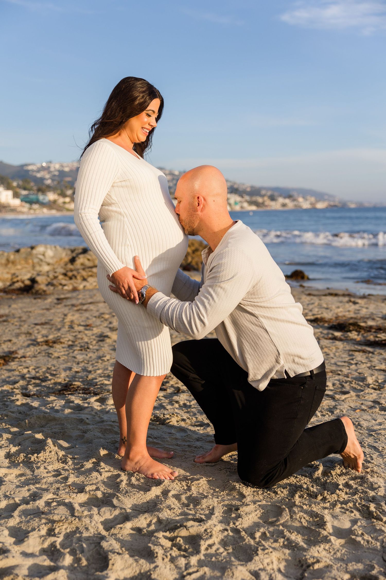 Maternity session at Laguna Beach with dad kissing his wife's belly
