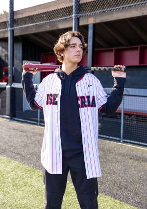 High school senior boy posing with his baseball bat