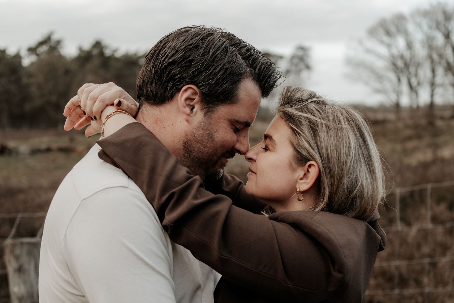 Handen van vriendin op de borst van haar vriend terwijl ze elkaar liefdevol aankijken