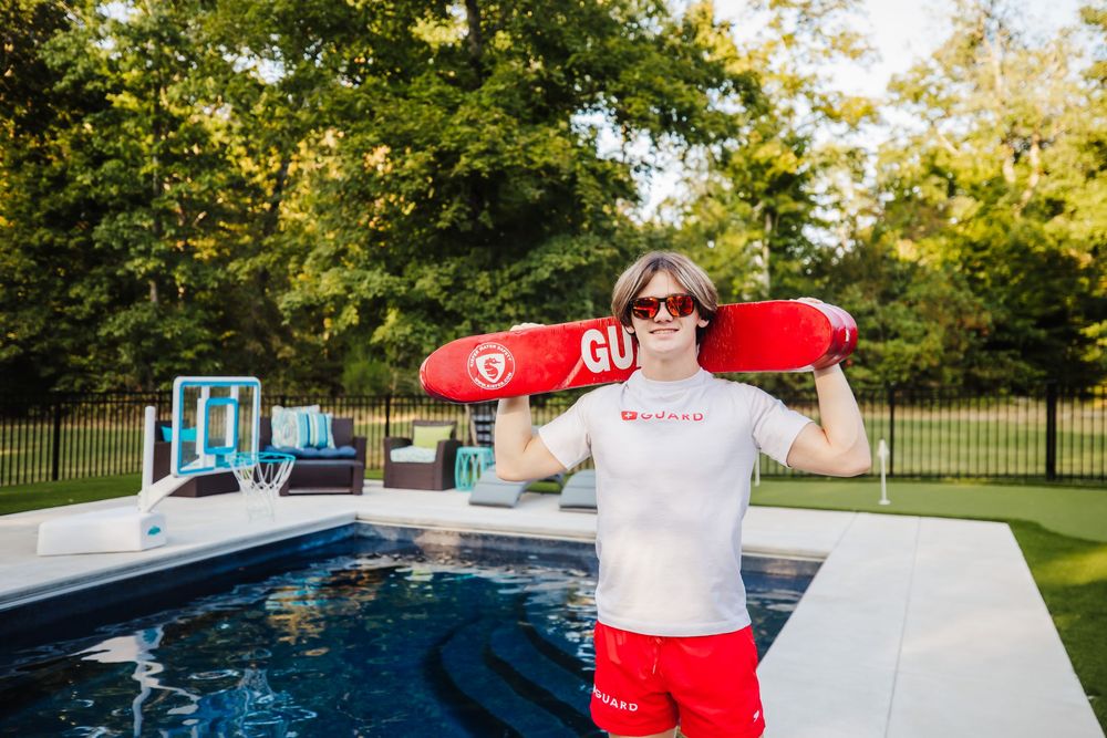 Senior boy poses as a lifeguard at the pool